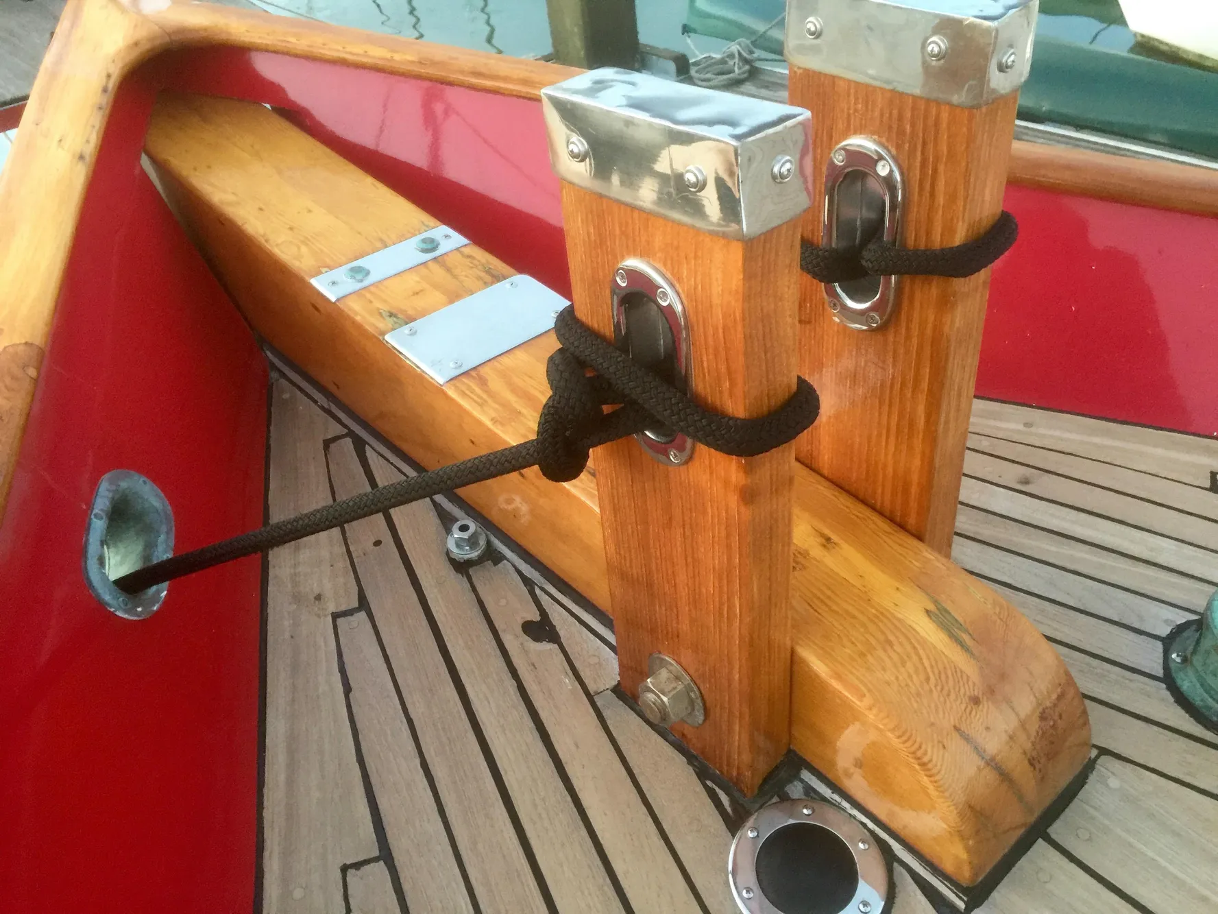 Wooden deck details of a 1971 Formosa 41 sailboat with red accents and metal fittings.