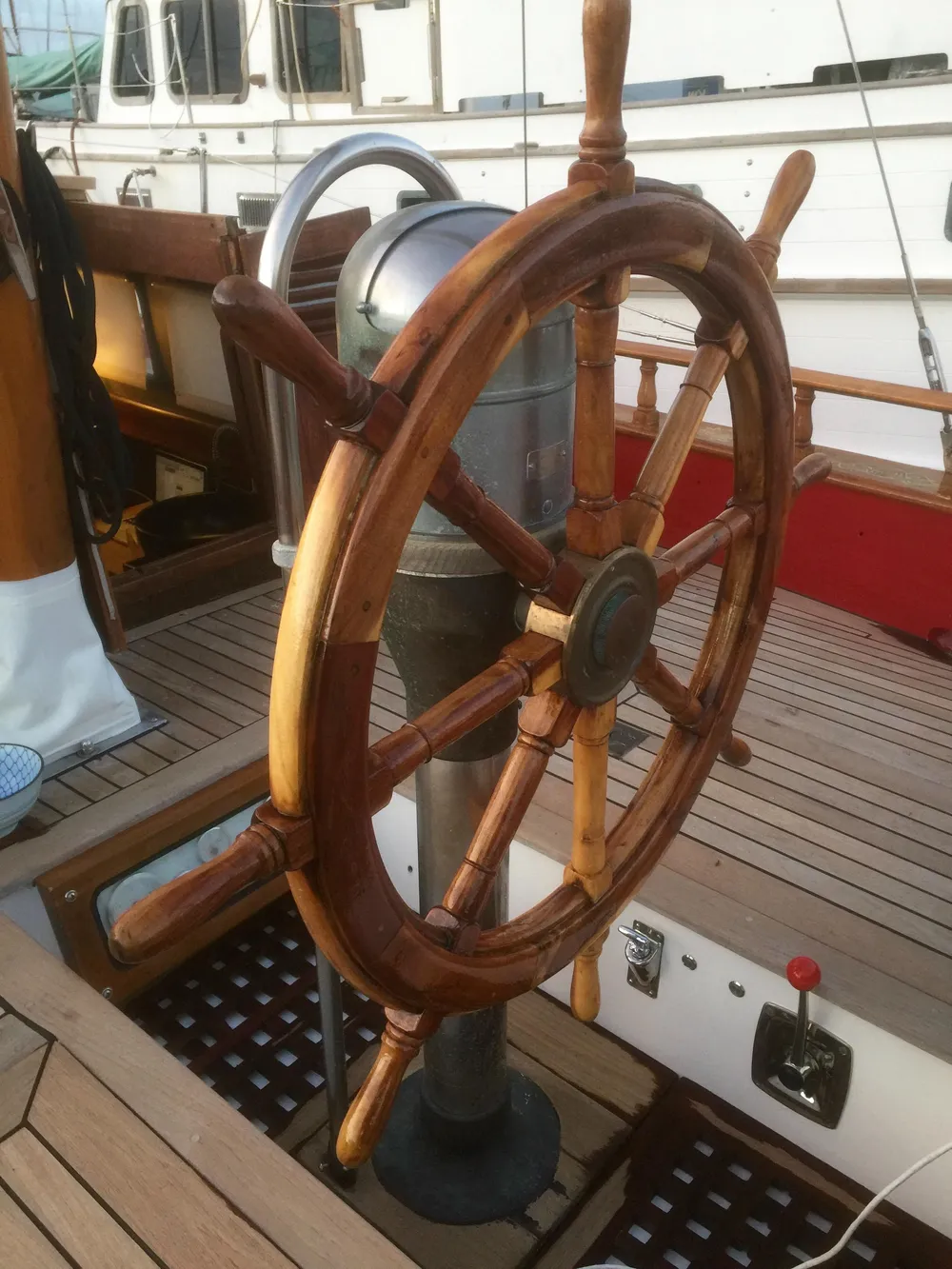 Wooden steering wheel on a 1971 Formosa 41 sailboat deck.