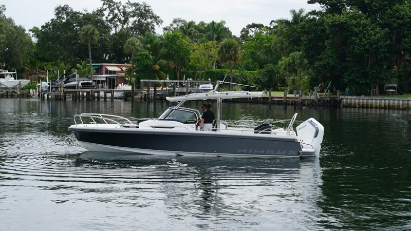 In-stock 2024 Nimbus T9 #143 Yacht Photos Pics 2024 Nimbus Tender 9 #143 boat cruising on a calm river near lush greenery.