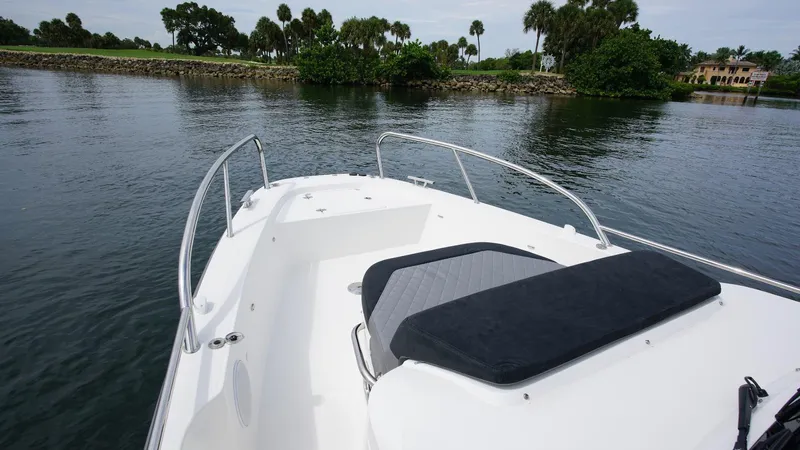 In-stock 2024 Nimbus T9 #143 Yacht Photos Pics 2024 Nimbus Tender 9 #143 boat on calm water with lush greenery in the background.