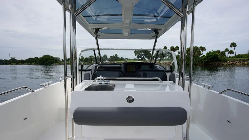 In-stock 2024 Nimbus T9 #143 Yacht Photos Pics 2024 Nimbus Tender 9 #143 boat interior with sink and seating, on calm water.