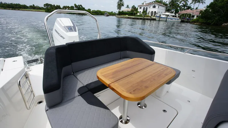 In-stock 2024 Nimbus T9 #143 Yacht Photos Pics Luxurious seating area on the 2024 Nimbus Tender 9 #143 boat with a wooden table.