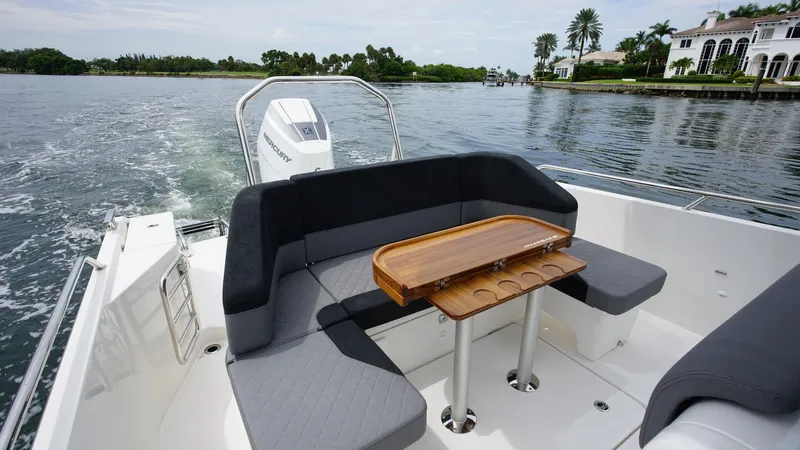 In-stock 2024 Nimbus T9 #143 Yacht Photos Pics 2024 Nimbus Tender 9 #143 boat with cushioned seating and wooden table on water.