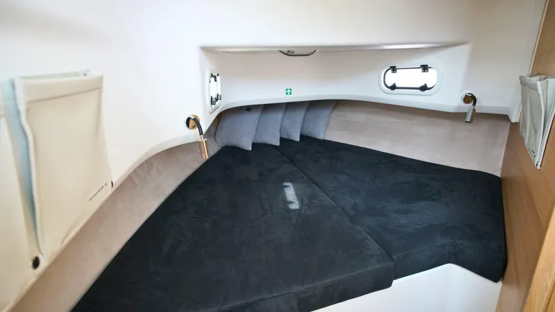In-stock 2024 Nimbus T9 #143 Yacht Photos Pics 2024 Nimbus Tender 9 #143 cabin interior with black bedding and porthole windows.