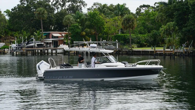In-stock 2024 Nimbus T9 #143 Yacht Photos Pics 2024 Nimbus Tender 9 #143 boat cruising on a calm river near a lush, green shoreline.