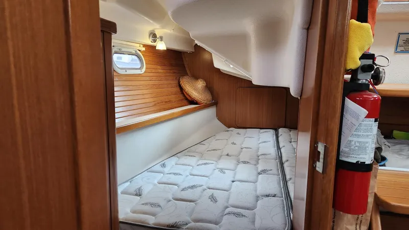  Yacht Photos Pics 2017 Catalina 315 yacht interior cabin with bed, wooden paneling, and fire extinguisher.