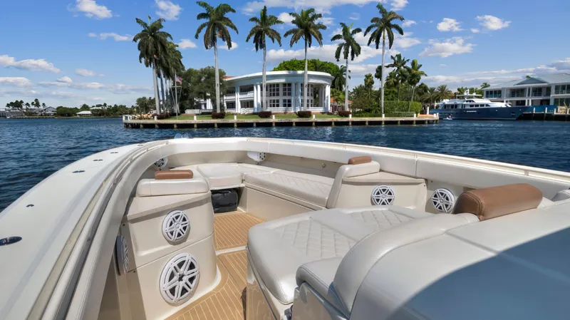 Strait To Voicemail Yacht Photos Pics Luxury 2018 HCB 53 Sueños boat with spacious seating, cruising near waterfront homes and palm trees.
