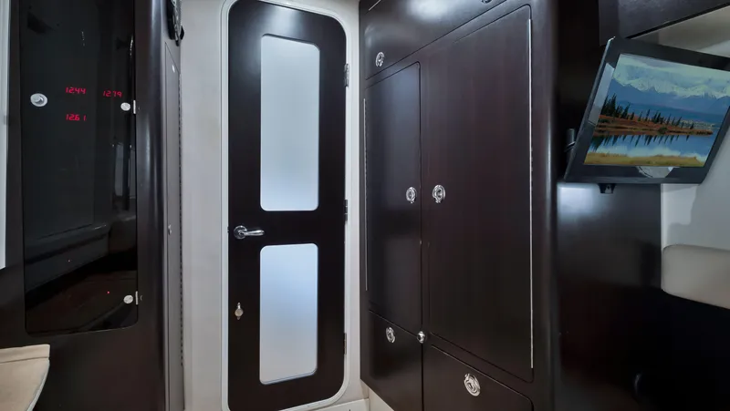 Strait To Voicemail Yacht Photos Pics Interior of 2018 HCB 53 Sueños yacht with dark wood cabinets and frosted glass door.