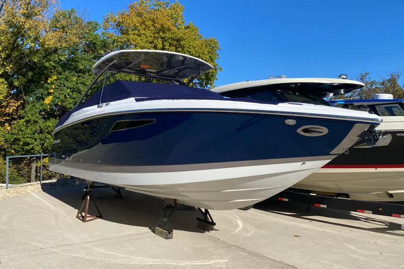  Yacht Photos Pics 2022 Cobalt R35 boat on display, blue and white design, sunny day, surrounded by trees.