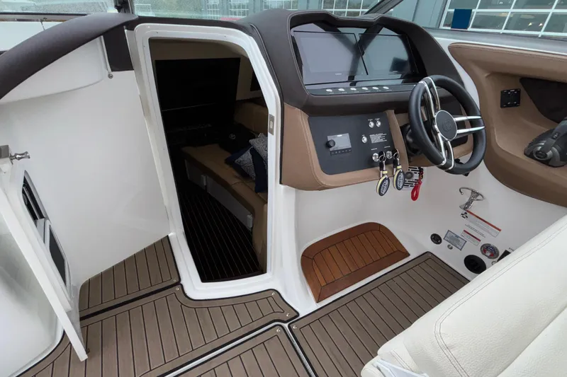  Yacht Photos Pics 2022 Cobalt R35 boat interior with helm, steering wheel, and cabin entrance.
