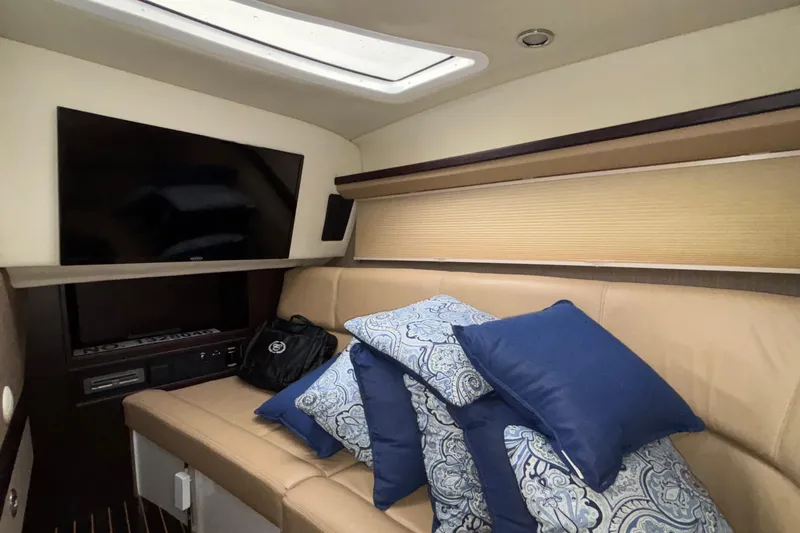  Yacht Photos Pics Luxurious interior of 2022 Cobalt R35 with TV, beige seating, and decorative pillows.