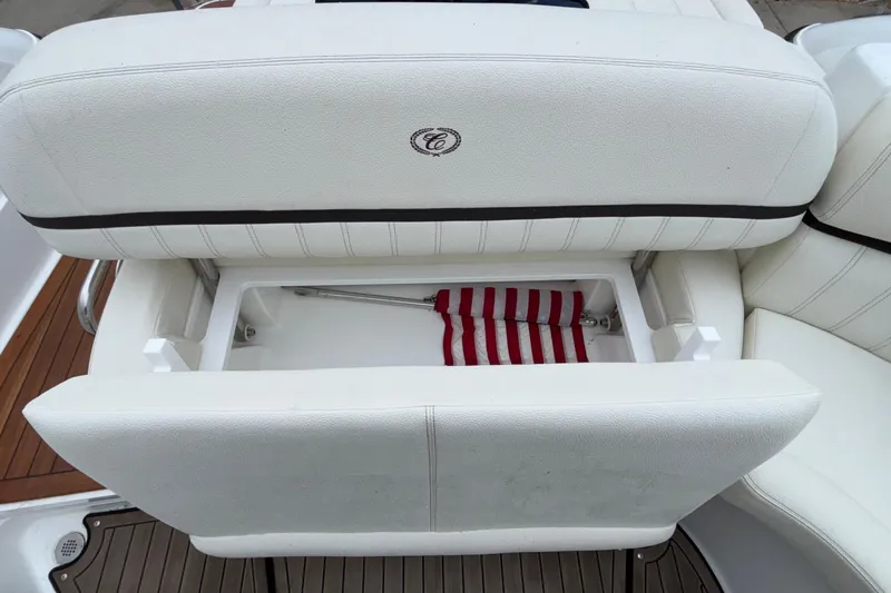  Yacht Photos Pics 2022 Cobalt R35 boat seat with storage compartment, featuring white upholstery and striped fabric.