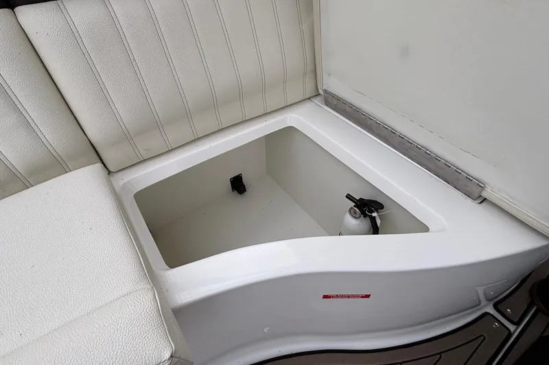  Yacht Photos Pics 2022 Cobalt R35 boat storage compartment with fire extinguisher, white cushioned seating.