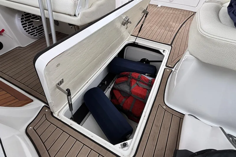  Yacht Photos Pics Open storage compartment on 2022 Cobalt R35 boat with cushions and a red bag.