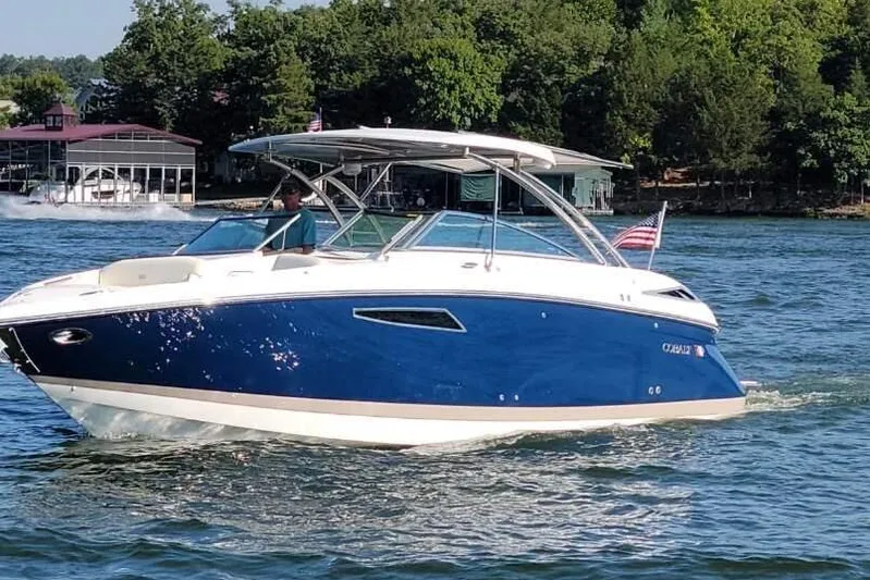  Yacht Photos Pics 2022 Cobalt R35 boat cruising on a lake with lush green trees in the background.