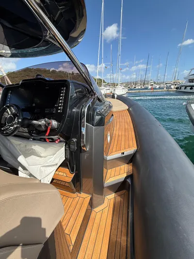  Yacht Photos Pics 2024 SACS Strider 15 yacht interior with wooden deck and control panel, docked at marina.