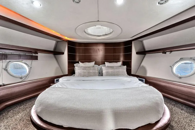  Yacht Photos Pics Luxurious bedroom interior of 2006 Azimut 68S yacht with elegant design and porthole windows.