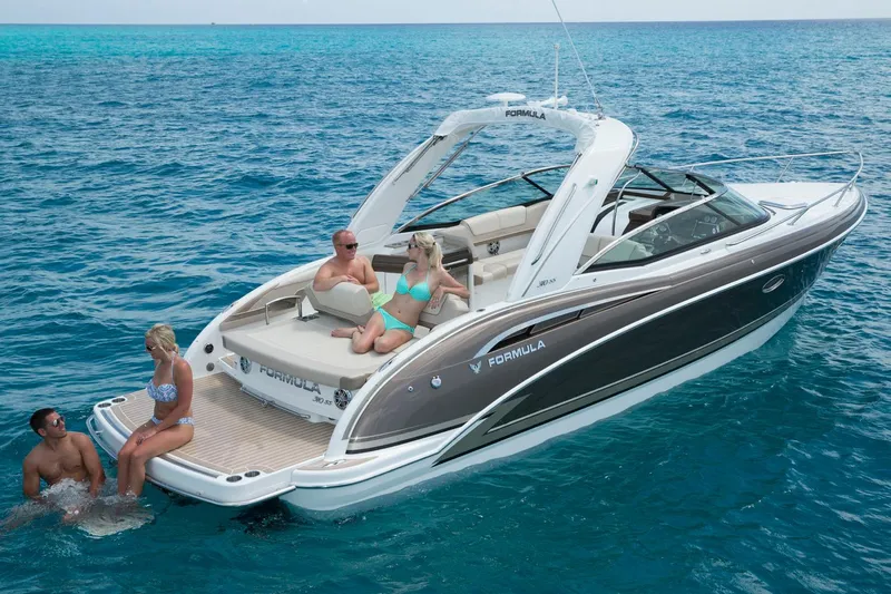 Yacht Photos Pics Manufacturer Provided Image: 2017 Formula 310 Sun Sport boat with people relaxing on deck in clear blue water.
