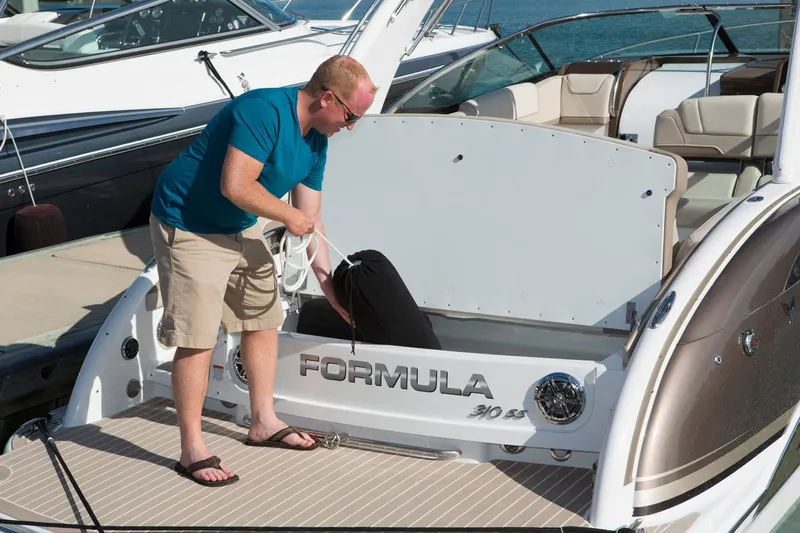  Yacht Photos Pics Manufacturer Provided Image: Man on a 2017 Formula 310 Sun Sport boat, organizing storage compartment.