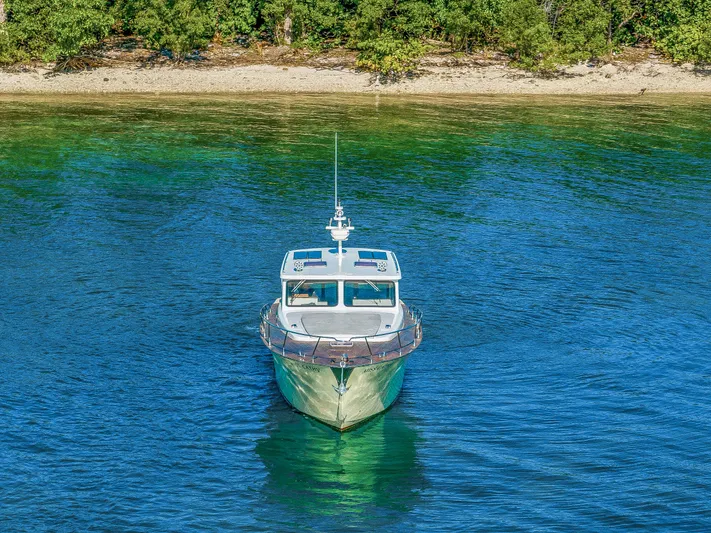 Miss Cathy Yacht Photos Pics Custom NNS Sea Scout 41 boat, 2007 model, on clear blue water near a forested shoreline.