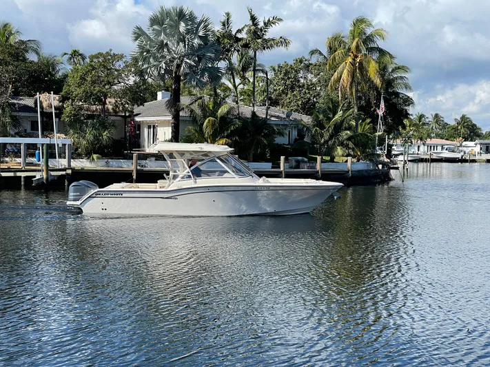  Yacht Photos Pics 2019 Grady-White Freedom 325 boat cruising on a scenic waterway with palm trees.