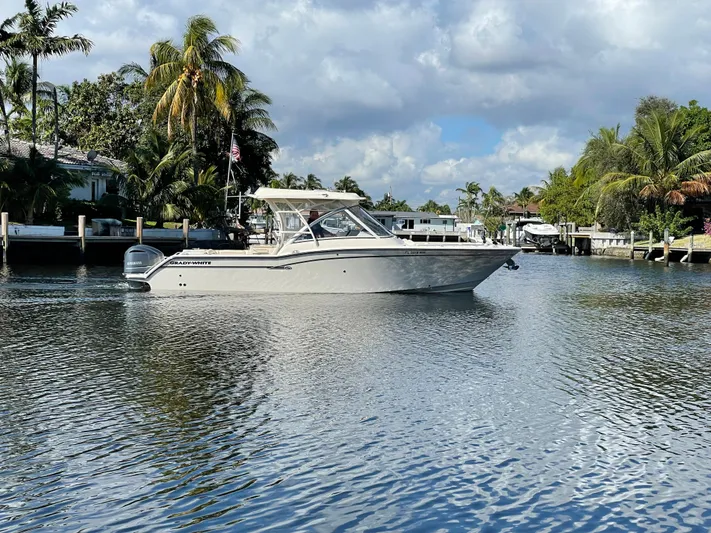  Yacht Photos Pics 2019 Grady-White Freedom 325 boat on a serene waterway with lush palm trees.