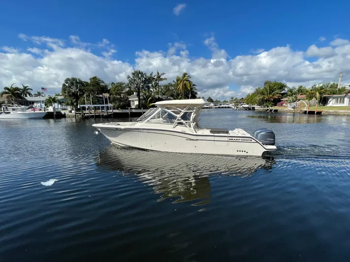  Yacht Photos Pics 2019 Grady-White Freedom 325 boat on a calm waterway under a clear blue sky.