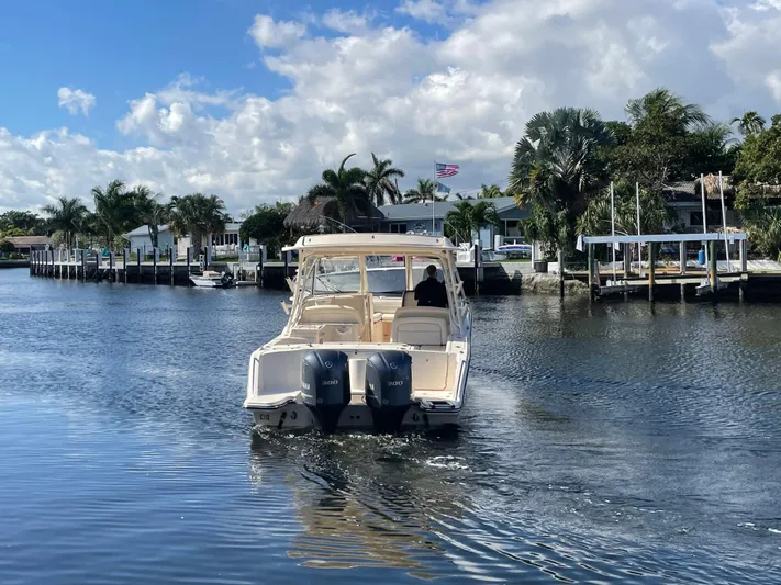  Yacht Photos Pics 2019 Grady-White Freedom 325 boat cruising on a scenic waterway with palm trees.