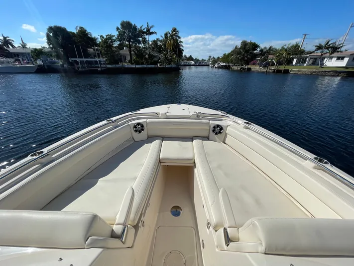  Yacht Photos Pics 2019 Grady-White Freedom 325 boat on a calm waterway, featuring spacious seating.