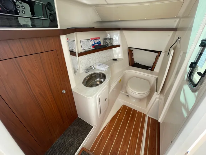  Yacht Photos Pics 2019 Grady-White Freedom 325 boat interior with sink, toilet, and wood accents.