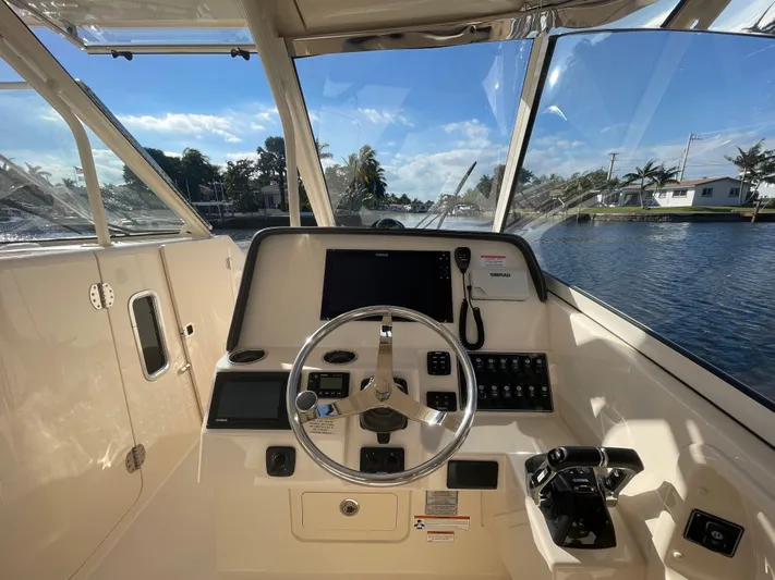  Yacht Photos Pics 2019 Grady-White Freedom 325 helm with steering wheel and controls, overlooking water.