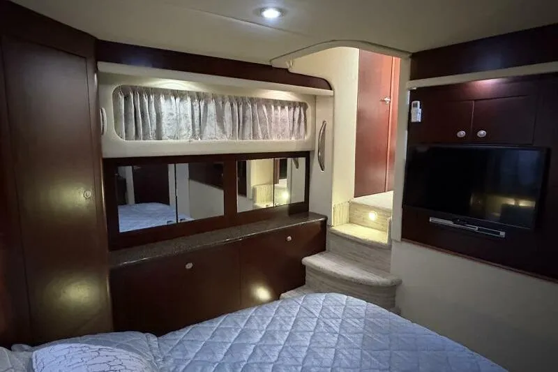 Inconspicuous Yacht Photos Pics Interior of 2006 Sea Ray 40 Motor Yacht with bed, TV, and wooden cabinetry.
