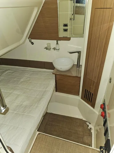  Yacht Photos Pics 2018 Chris-Craft 30 Catalina cabin interior with bed, sink, and wooden accents.