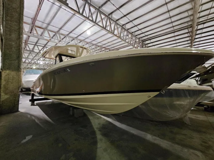 Yacht Photos Pics 2018 Chris-Craft 30 Catalina boat in storage, side view under metal roof.
