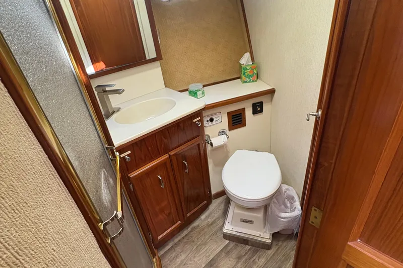 Monkey Business Yacht Photos Pics Bathroom interior of 1988 Egg Harbor 37 Convertible yacht, featuring wood cabinetry and modern fixtures.