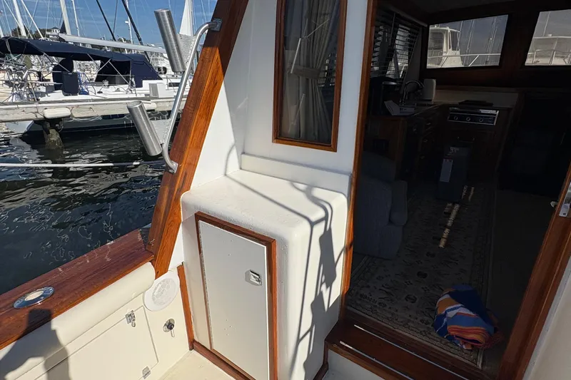 Monkey Business Yacht Photos Pics 1988 Egg Harbor 37 Convertible yacht interior with marina view, showcasing wood accents and cozy cabin.