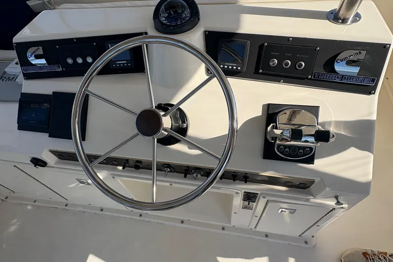 Monkey Business Yacht Photos Pics 1988 Egg Harbor 37 Convertible boat helm with steering wheel and Cummins turbo diesel controls.