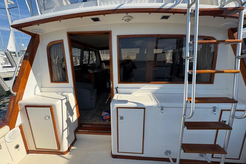Monkey Business Yacht Photos Pics 1988 Egg Harbor 37 Convertible yacht with wooden accents and ladder, docked at marina.