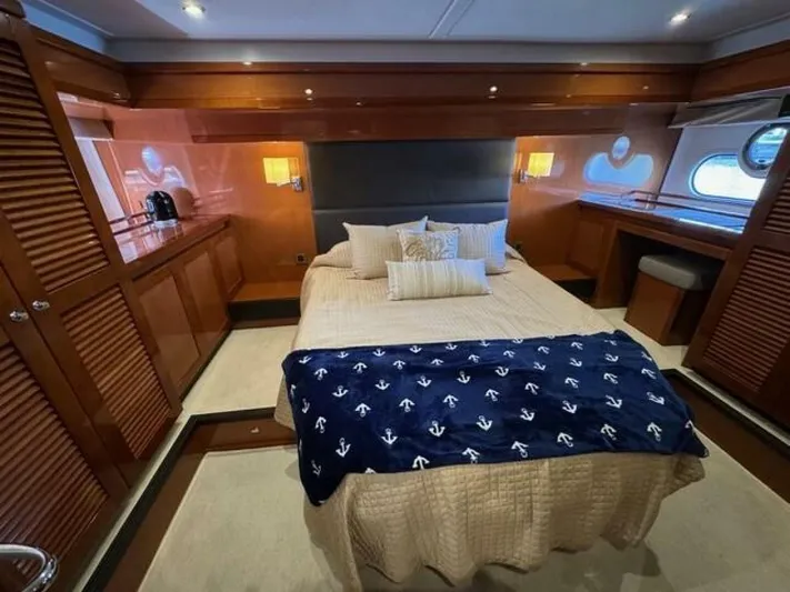 Candy Girl Yacht Photos Pics Luxurious cabin interior of 2017 Beneteau Swift Trawler 50 with cozy bedding and elegant wood finishes.