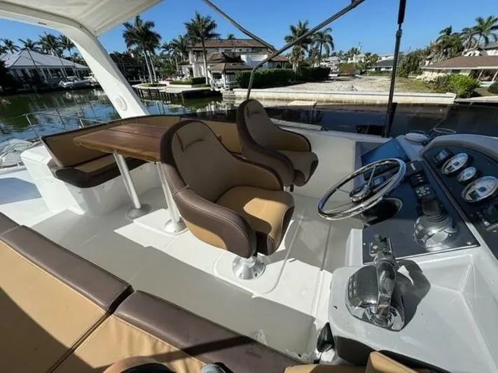 Candy Girl Yacht Photos Pics 2017 Beneteau Swift Trawler 50 helm with seating, docked near waterfront homes.