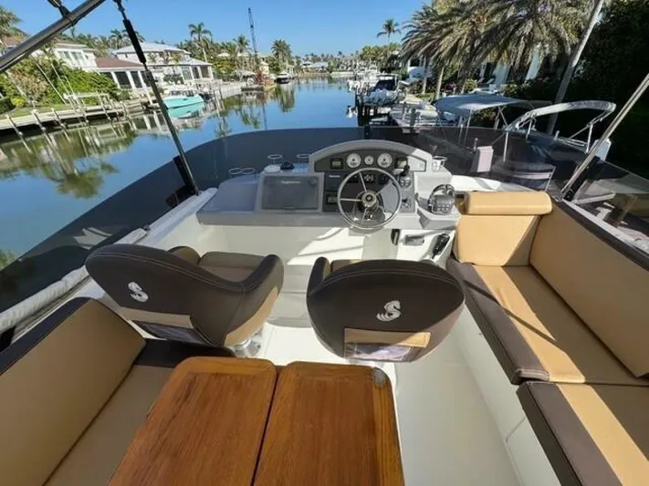 Candy Girl Yacht Photos Pics 2017 Beneteau Swift Trawler 50 helm with seating, docked in a scenic canal setting.
