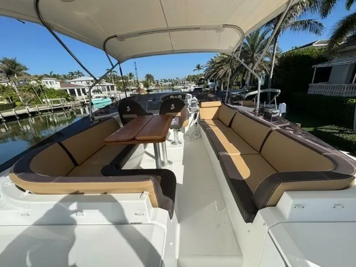 Candy Girl Yacht Photos Pics 2017 Beneteau Swift Trawler 50 deck with seating, table, and canopy in a marina setting.