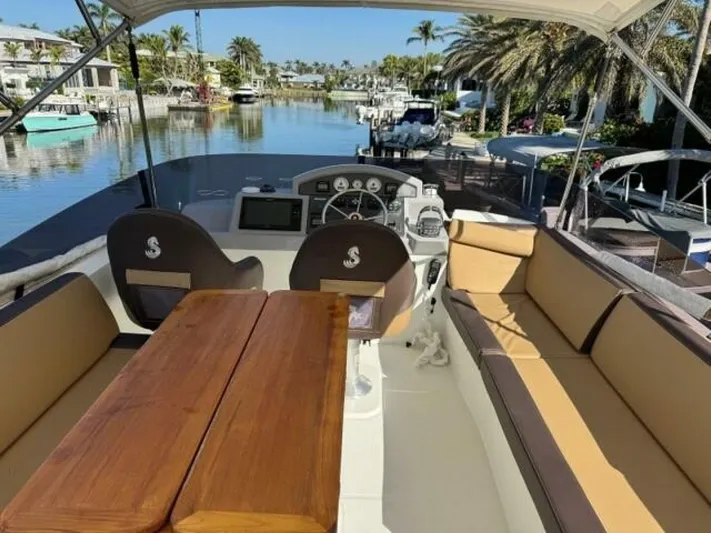 Candy Girl Yacht Photos Pics 2017 Beneteau Swift Trawler 50 interior with seating and helm, docked in a scenic canal.