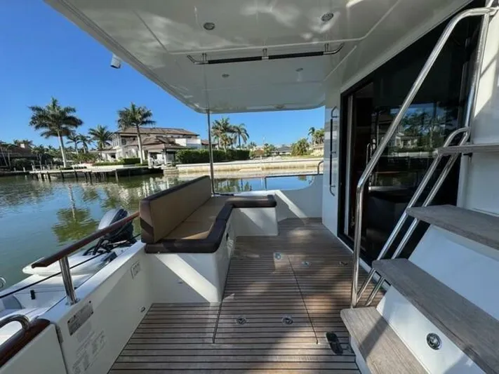Candy Girl Yacht Photos Pics 2017 Beneteau Swift Trawler 50 deck with seating, docked by waterfront homes.