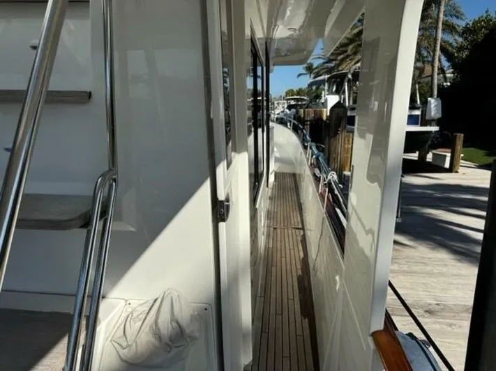Candy Girl Yacht Photos Pics 2017 Beneteau Swift Trawler 50 side deck with wooden flooring and railing.