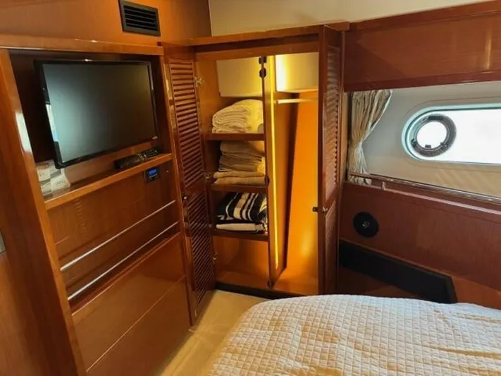 Candy Girl Yacht Photos Pics Interior of 2017 Beneteau Swift Trawler 50 with TV, wardrobe, and porthole window.