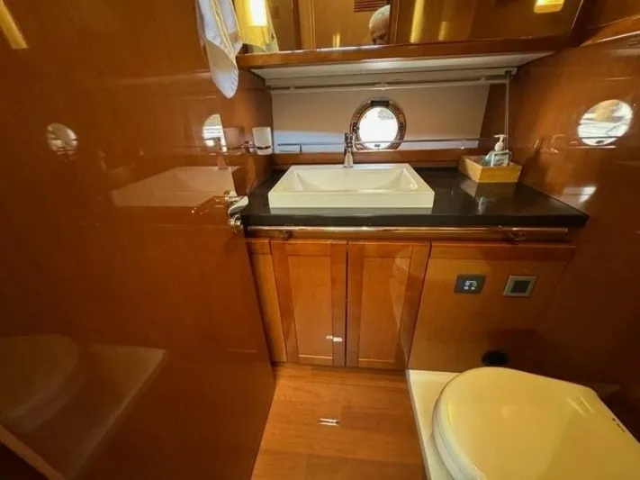 Candy Girl Yacht Photos Pics Luxurious bathroom in 2017 Beneteau Swift Trawler 50 yacht with wood finish and modern fixtures.