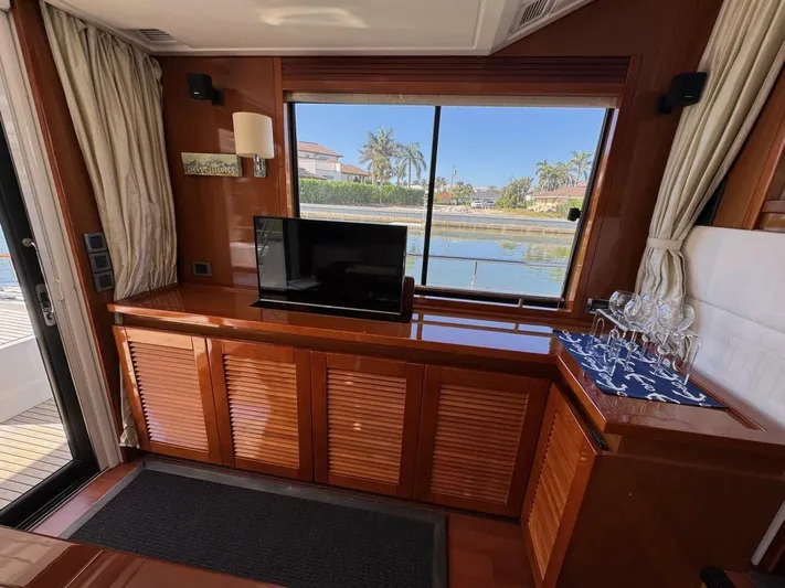 Candy Girl Yacht Photos Pics Interior of 2017 Beneteau Swift Trawler 50 with TV, window view, and elegant wood finish.