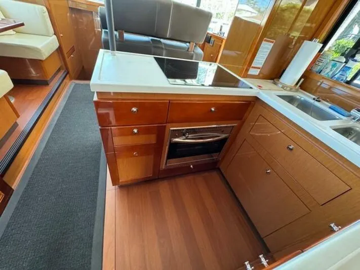 Candy Girl Yacht Photos Pics 2017 Beneteau Swift Trawler 50 kitchen with wood cabinetry, stove, and sink.