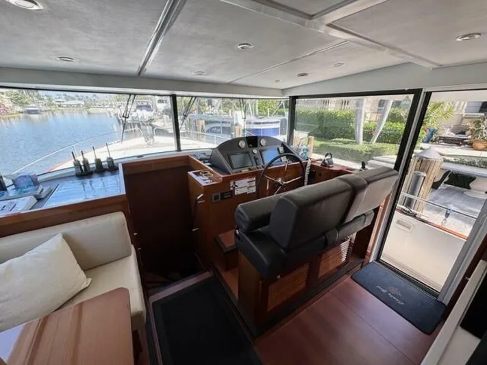 Candy Girl Yacht Photos Pics Interior of 2017 Beneteau Swift Trawler 50, featuring helm and seating area with waterfront view.